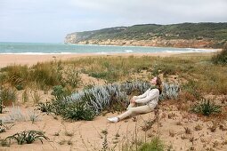 Woman sitting on the beach, Barbate, Cadiz, Andalusia, Spain
