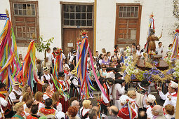 Dancing group of women and men in canrian traditional costume in a procession following San Isidro behind of the church in Los Realejos, Romeria, Tenerife, Canary Islands, Spain