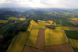 Aerial view of rapeseed fields in flower, village of Tuchtfeld in the Weser Hills, Lower Saxony, Germany