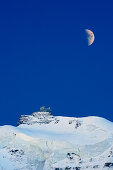 Moon above station of Jungfraujoch, Jungfrau, Grindelwald, UNESCO World Heritage Site Swiss Alps Jungfrau - Aletsch, Bernese Oberland, Bern, Switzerland, Europe