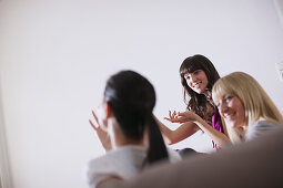 Three young women sitting on a sofa, Munich, Bavaria, Germany