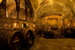 Candlelit barrels inside wine cellar of Eberbach abbey, a medieval monastery at Eltville am Rhein, Rheingau, Hesse, Germany, Europe