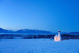 Verschneite Kirche vor Alpenkette am Abend, Penzberg, Werdenfelser Land, Oberbayern, Bayern, Deutschland, Europa