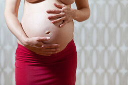 Schwangere Frau berührt ihren Bauch, Leipzig, Sachsen, Deutschland