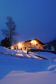 Beleuchtete Hütte auf Schneehügel, Albert-Link-Hütte, Spitzinggebiet, Bayerische Alpen, Oberbayern, Bayern, Deutschland, Europa