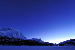 Night sky above snow-covered lake Silser See, with view to Malojapass, lake Silser See, Bernina range, Upper Engadin, Engadin, Grisons, Switzerland, Europe