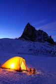 Beleuchtetes Zelt auf Schneefläche vor Felsturm Ra Gusela, Passo Giau, Cortina d' Ampezzo, UNESCO Weltkulturerbe Dolomiten, Dolomiten, Venetien, Italien, Europa