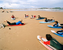 Surflehrer mit Schülern, Escuela cantabria de surf, Playa de Somo, bei Santander, Kantabrien, Spanien
