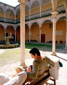 Couple in the courtyard of Escuela de Artes art school in Casa de las Torres, Úbeda, Andalusia, Spain