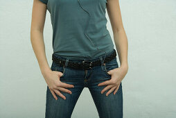 Female wearing jeans, hands in pockets, mid section
