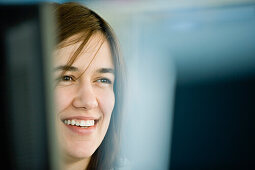 Young woman using computer, smiling