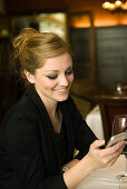 Woman text messaging in restaurant