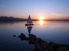 Sailboat at sunset, Lake Chiemsee, Chiemgau, Bavaria, Germany