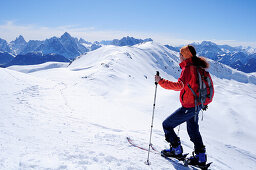 Woman backcountry skiing looking towards Sexten Dolomites, Marchkinkele, Villgraten range, Hohe Tauern range, East Tyrol, Austria