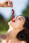 Young woman eating red currents