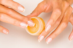 Woman's hands holding  lipbalm in a little box