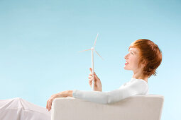Young woman holding mini wind turbine