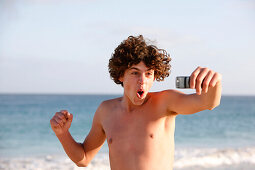 Teenage boy photographing himself