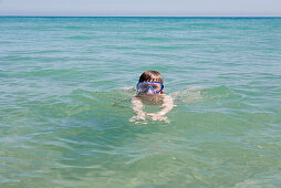 Boy with diving goggles swimming in Atlantic Ocean, Costa Calma, Fuerteventura, Canary Islands, Spain