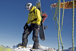 Snowboarder preparing a climbing rope, Oberjoch, Bad Hindelang, Bavaria, Germany