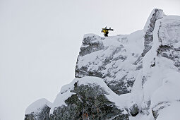 Snowboarder steht auf einem Berggipfel, Chandolin, Anniviers, Wallis, Schweiz