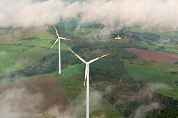 Aerial view of wind wheels at a wind turbine park in the fog, Eifel, Rhineland Palatinate, Germany, Europe