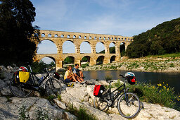 Cyclists having a rest near the aquaduct, Pont du Gard, Provence, France