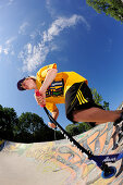 Junger Mann mit einem Tretroller in einer Skating-Anlage, München, Oberbayern, Bayern, Deutschland