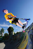 Young man performing jump with scooter, skate park, Munich, Upper Bavaria, Germany