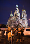 Young Russian women party in front of limousine at Church of the Savior on Spilled Blood (Church of the Resurrection) at night, St. Petersburg, Russia