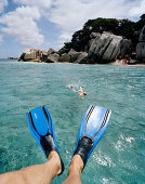 Snorkelling in shallow water over coral reef near tiny Coco Island, La Digue and Inner Islands, Republic of Seychelles, Indian Ocean