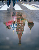 Pedestrians walking in front of the St. Basil's Cathedral on Red Square, reflektions in a puddle, Moscow, Russia, Europe