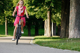 Woman cycling through Rosenstein Park, bike tour, Rosenstein Park, Stuttgart, Baden-Wurttemberg, Germany
