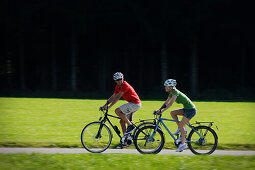 Cyclists riding e-bikes, Lake Starnberg, Bavaria, Germany