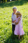 Sibling (5 and 7 years) standing on meadow, Lake Starnberg, Bavaria, Germany