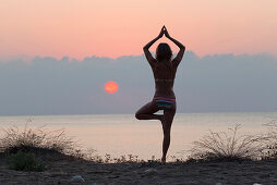 Frau macht Yoga bei Sonnenaufgang am Mittelmeer, lykische Küste, Lykien, Türkei, Europa