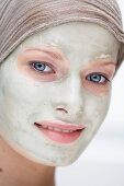 Porträt einer jungen Frau mit einer Schönheitsmaske auf dem Gesicht