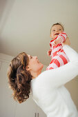 Woman holding her baby, smiling