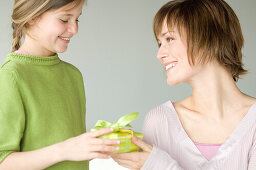 Little girl giving present to woman