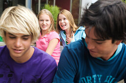 2 teen girls and 2 teen boys smiling, outdoors