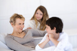 Senior woman and two children, indoors