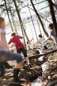 Children playing along the lakeshore, jumping over a stream, Leoni castle grounds, Leoni, Berg, Lake Starnberg, Bavaria, Germany