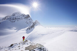 Mountaineer at the summit of Jungfraujoch, Jungfrau in the background, Grindelwald, Bernese Oberland, Switzerland