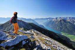 Woman walking at Unnutz with view to lake Achensee, Rofan range and Alpine main ridge, Unnutz, Unnuetz, Rofan, Tyrol, Austria