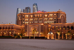 Strand und das Emirates Palace Hotel in der Abenddämmerung, mit Hochhäusern im Hintergrund, Abu Dhabi, Vereinigte Arabische Emirate