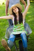 Young woman sitting in wheelbarrow