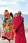 Monk taking pictures at mask dance at monastery festival, Phyang, Leh, valley of Indus, Ladakh, Jammu and Kashmir, India