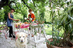 Women setting up the breakfast table in the garden, B and B Chambre Avec Vue, Luberon, France