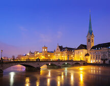 Illuminated buildings and church Frauenmuenster with river Limmat in foreground, Zurich, Switzerland