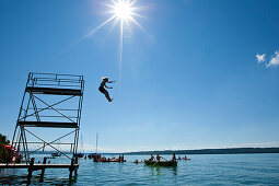 Child jumping into Lake Starnberg, Upper Bavaria, Germany, Europe